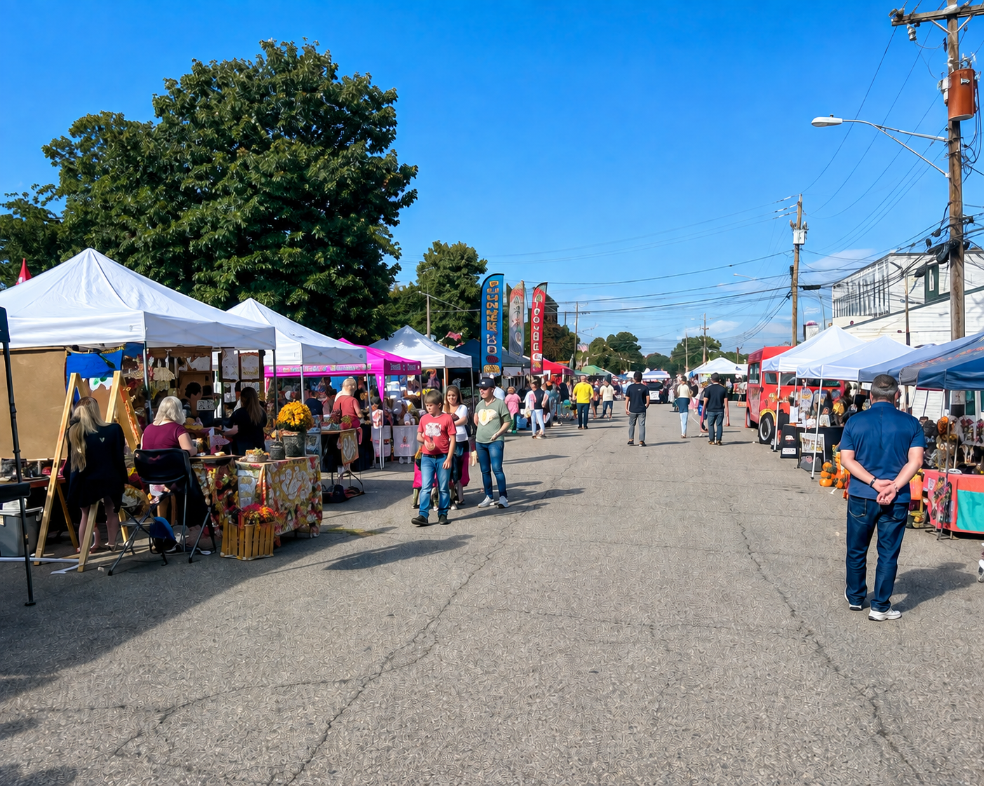 Vendor tents and visitors along a closed downtown street during a Yadkinville festival